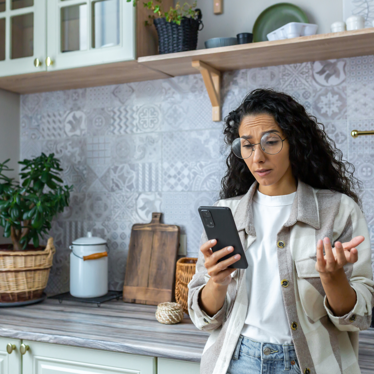 WTF? A brunette woman staring at her phone very shocked. 